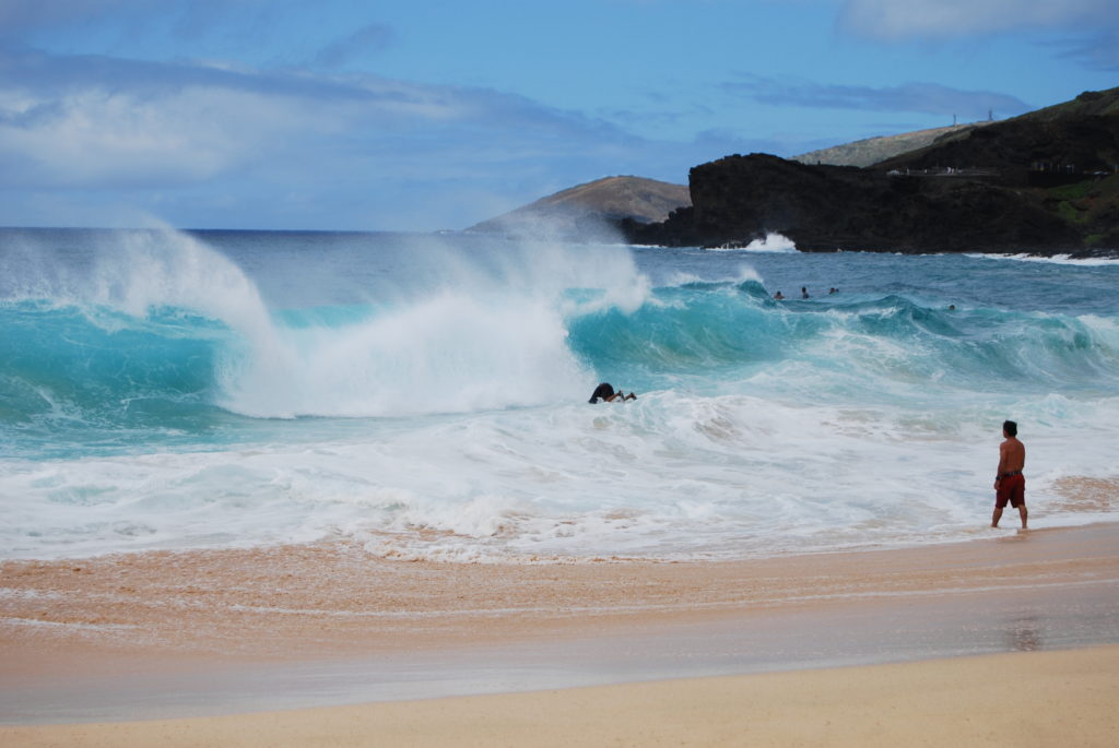 man bodysurfing at Sandy Beach